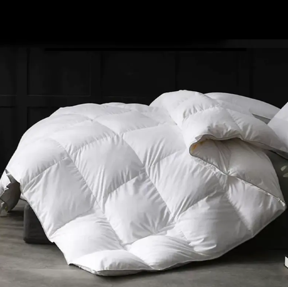 ¿Cuáles son las ventajas de usar Down como material de llenado para colchas de hotel?